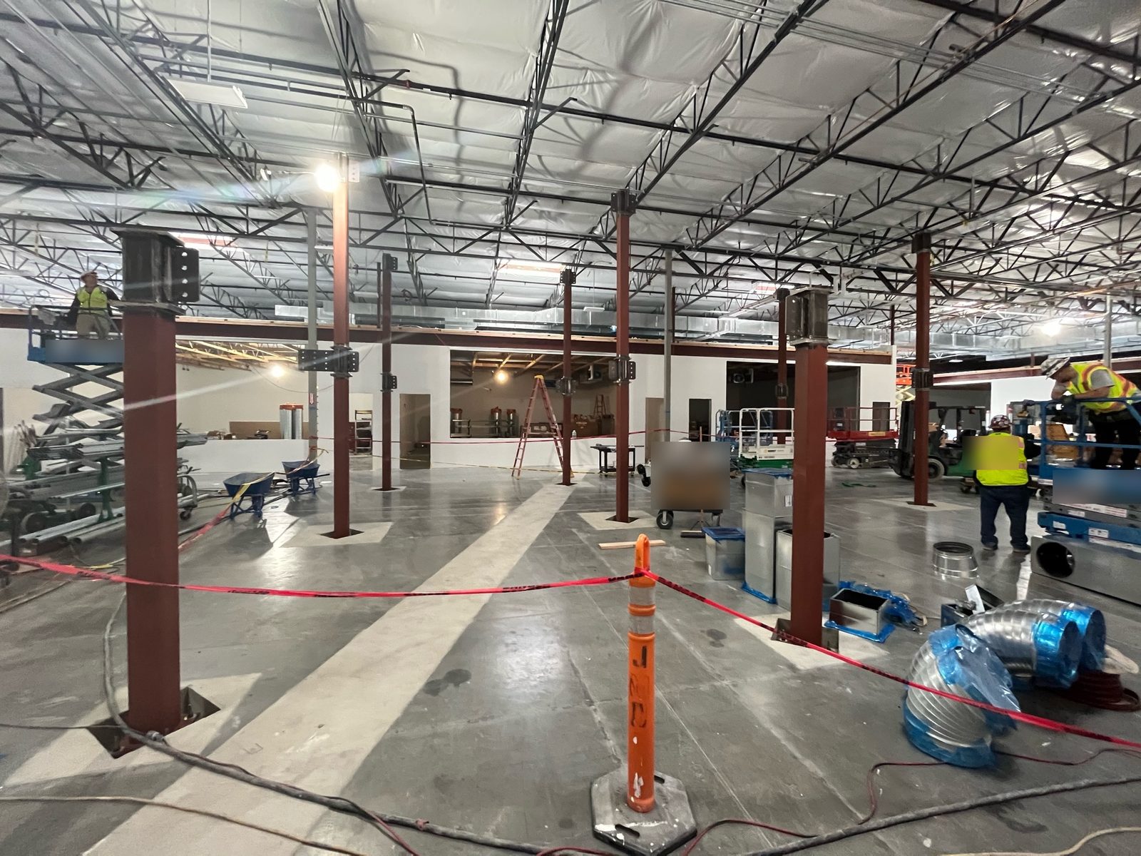 Installed mezzanine columns with trades working on lifts nearby