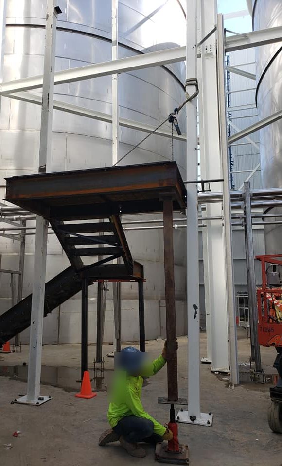 Stair flight and landing being set between the tanks on site